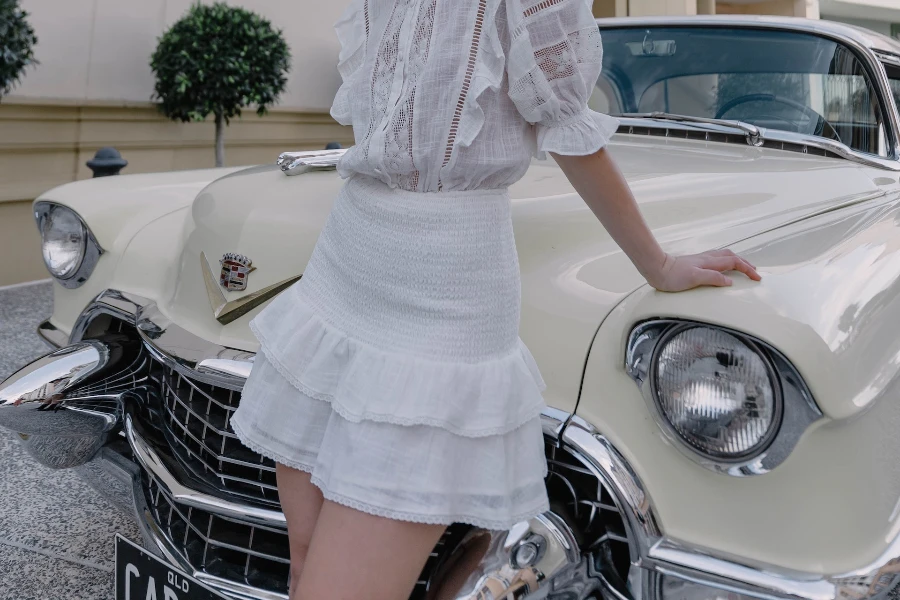 Senhora posando em um carro balançando uma saia de declaração