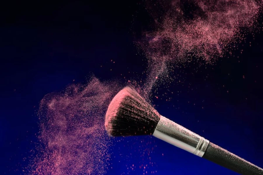Makeup brush with pink blush on the tip