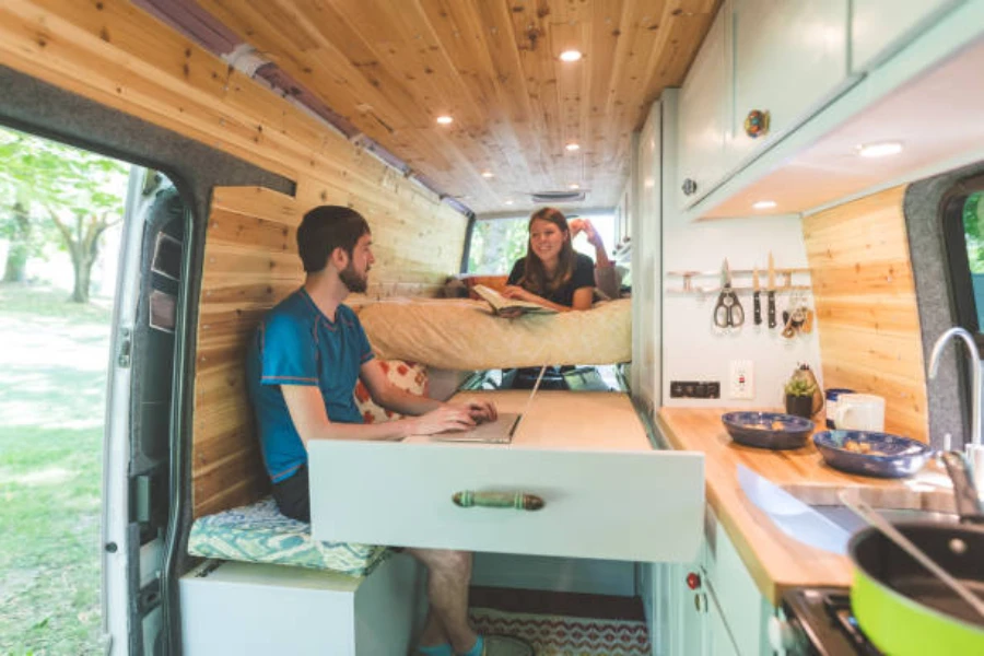 Man and woman sitting inside modern camper van
