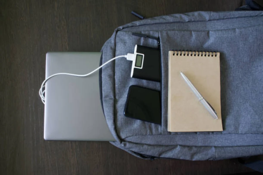 Navy backpack with laptop and portable charger hanging out