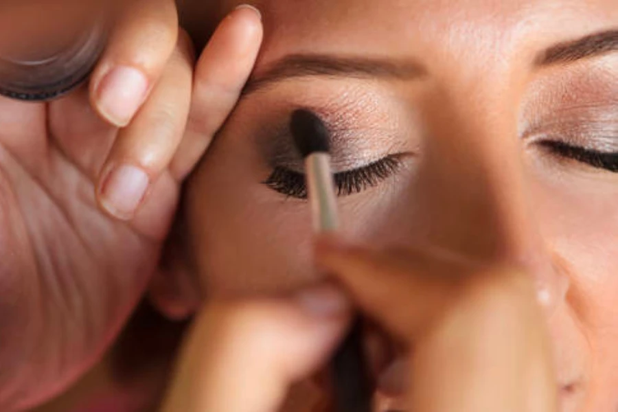 Person using a crease definer brush to blend eyeshadow