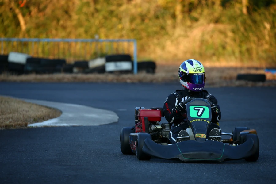 Person with a helmet driving a go kart on a track