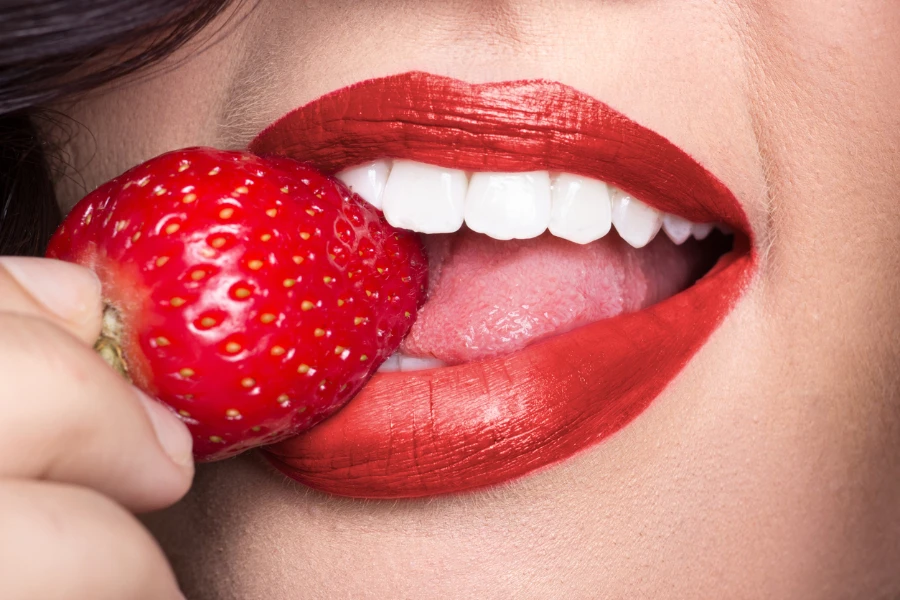 Red lipstick and a strawberry