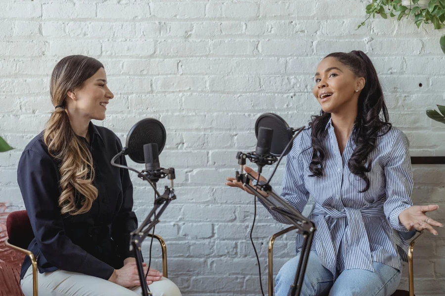 Dos mujeres sentadas en sillas grabando un podcast