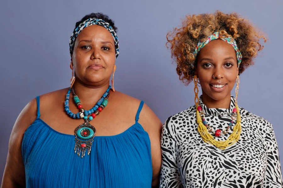 Two women wearing patterned headbands and bright jewelry