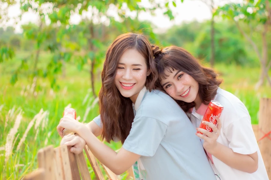 Two young Asian women smiling in nature