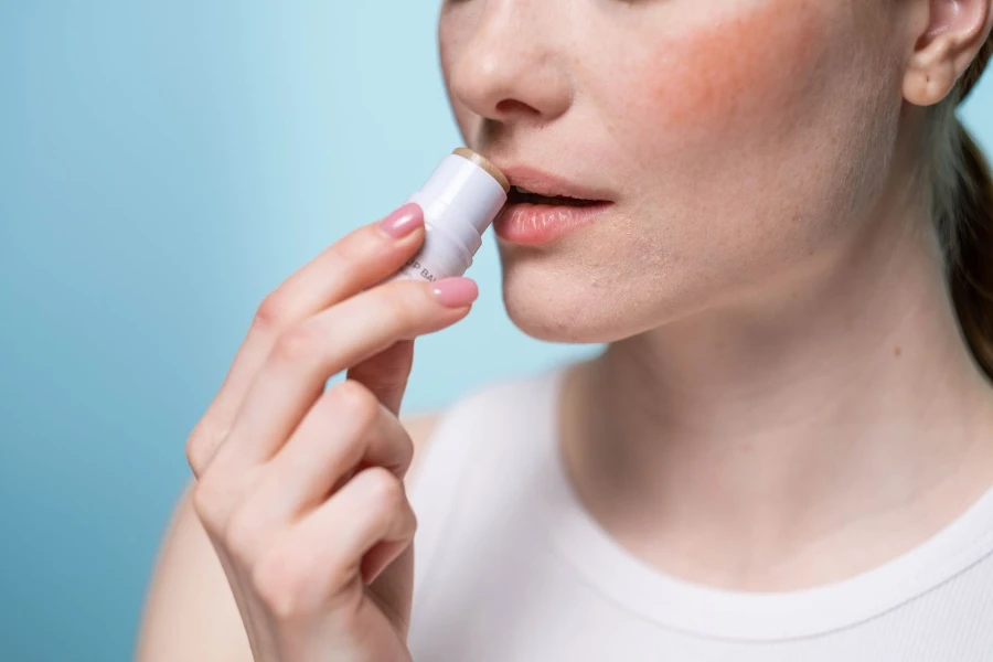 Mulher aplicando um produto labial