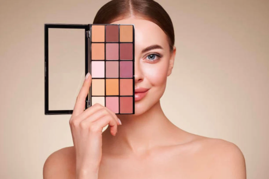 Mujer sosteniendo una paleta de sombras de ojos en tonos naturales