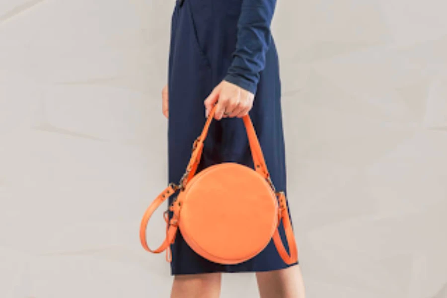 Woman wearing a blue dress holding a structured handbag
