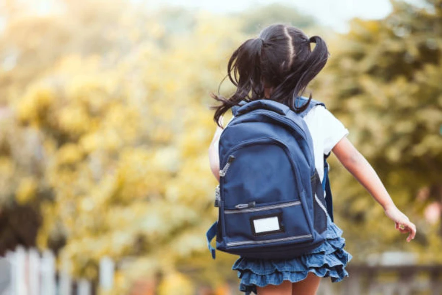 Young girl with pigtails wearing blue lightweight backpack