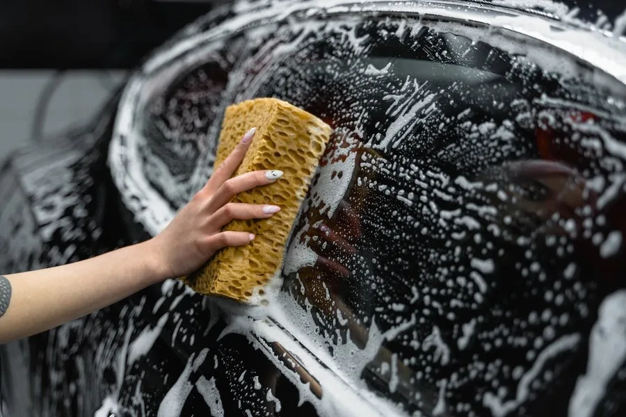 A hand washing a car