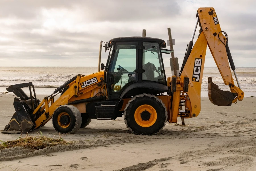 a JCB backhoe loader at rest on a beach