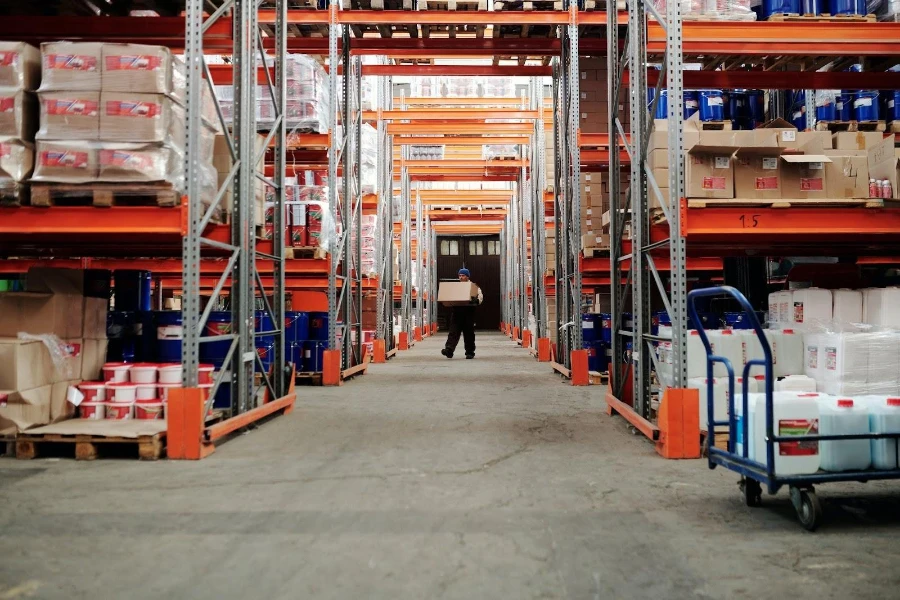 A large warehouse with a worker carrying a box in the middle