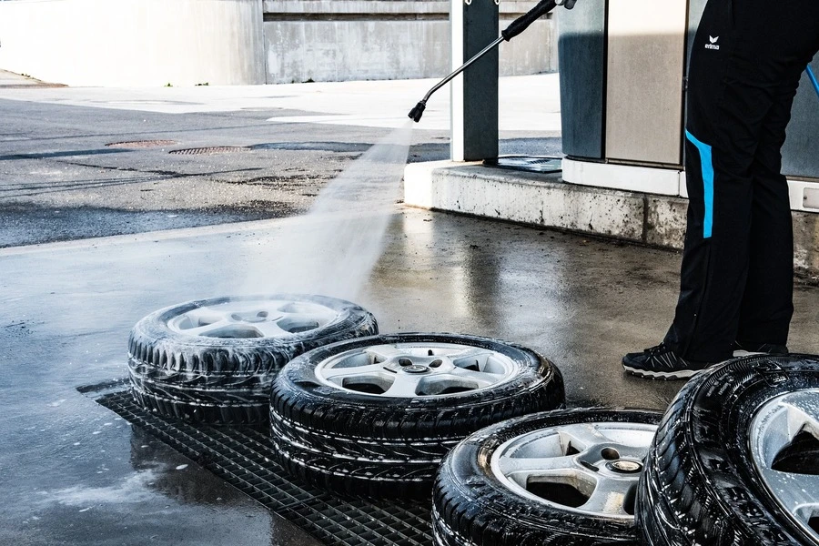 A man washing tires in a garage
