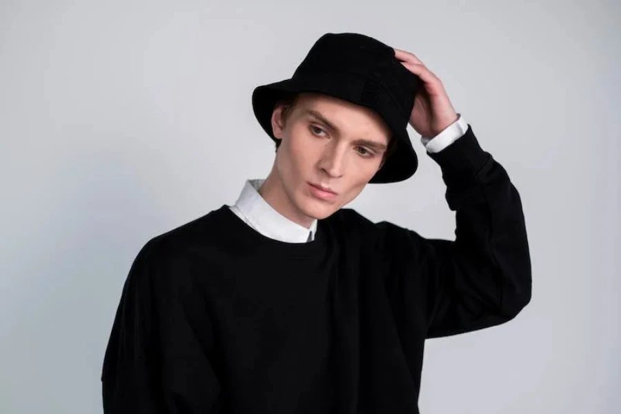 A man wearing a black bucket hat and collared shirt