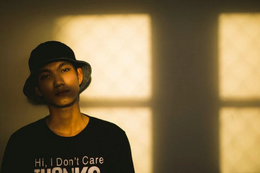 A man wearing a T-shirt and dark-colored bucket hat