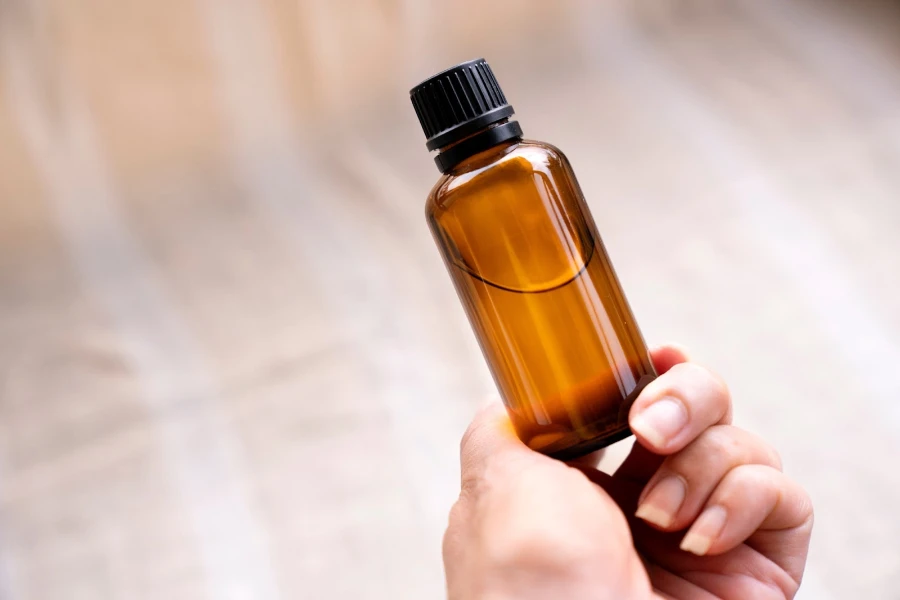 A person holding a brown bottle