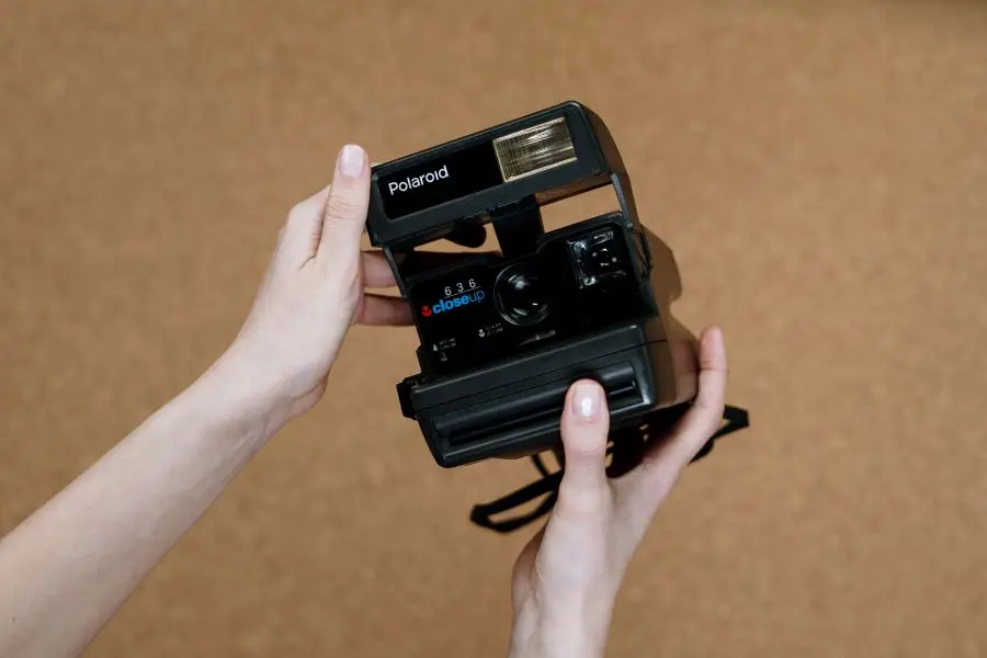 A person holding a Polaroid instant camera