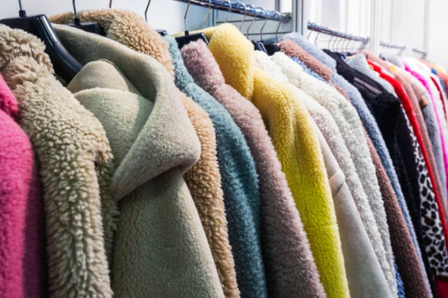 A rack of different colored winter coats
