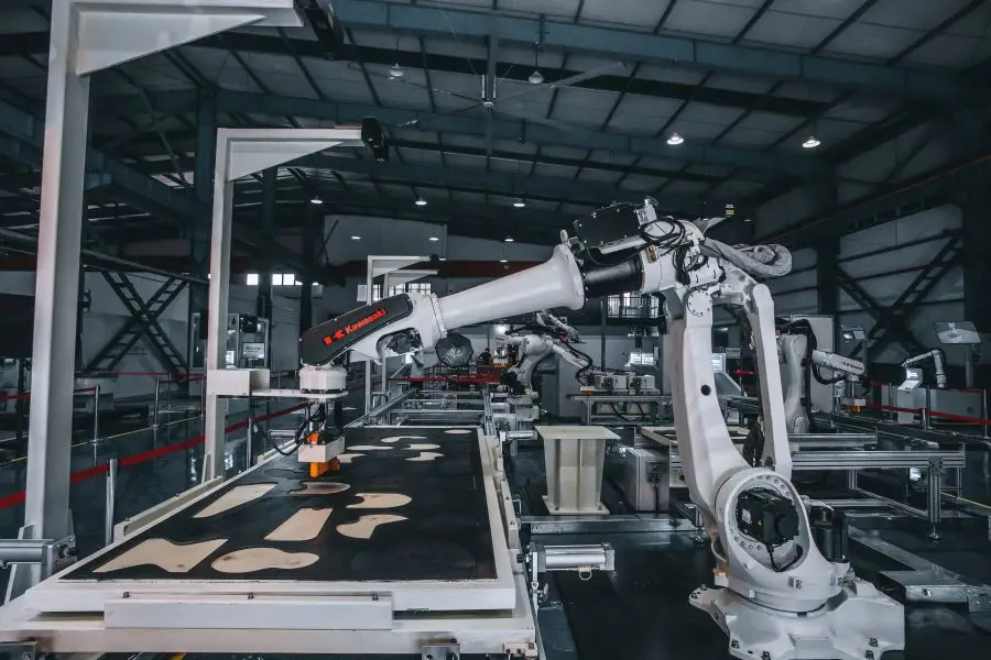 A white robot machine working in a factory