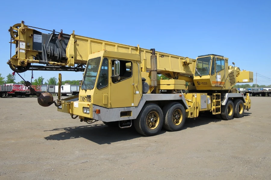A yellow boom truck with a man bucket