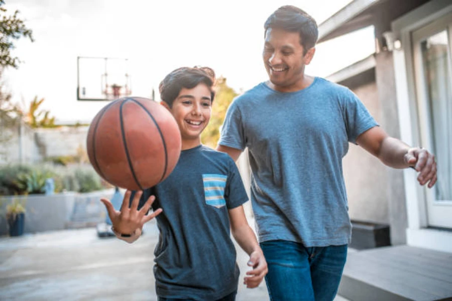 Boy walking with father holding an adult sized basketball