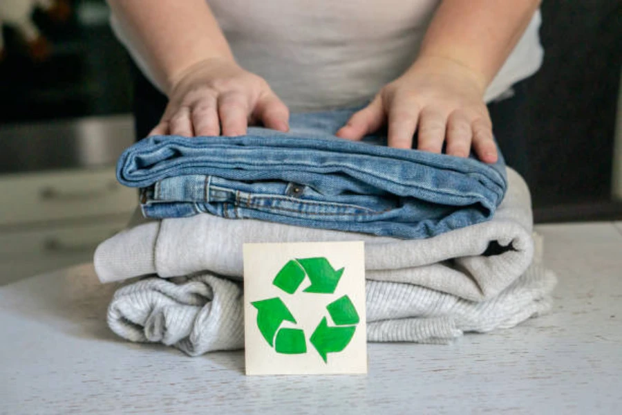 Folded clothes with the recycling symbol in front of them