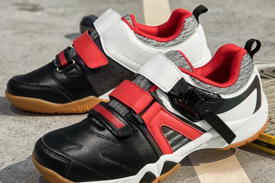 Pair of white, black, and red unisex table tennis shoes