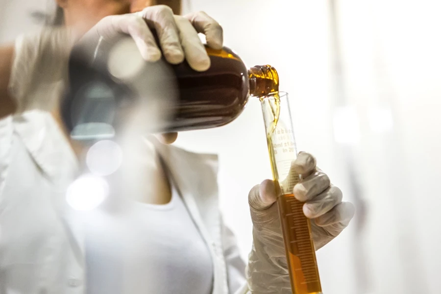 Perfumista sosteniendo una botella marrón y un tubo de ensayo