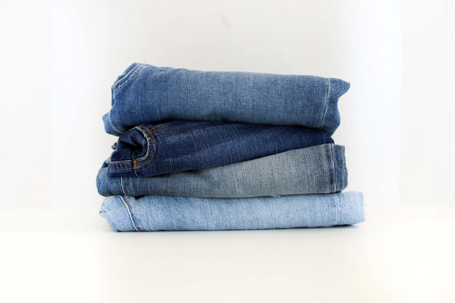 Pile of women’s jeans on white counter