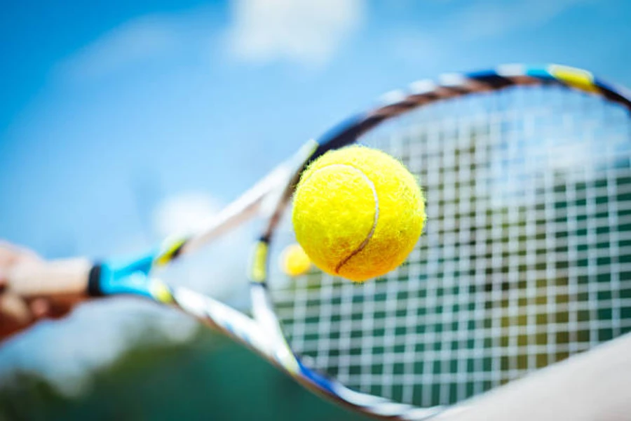 Player hitting a yellow tennis ball in center of racquet