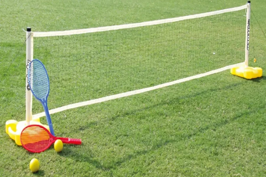 Small tennis net on grass with plastic tennis racquets