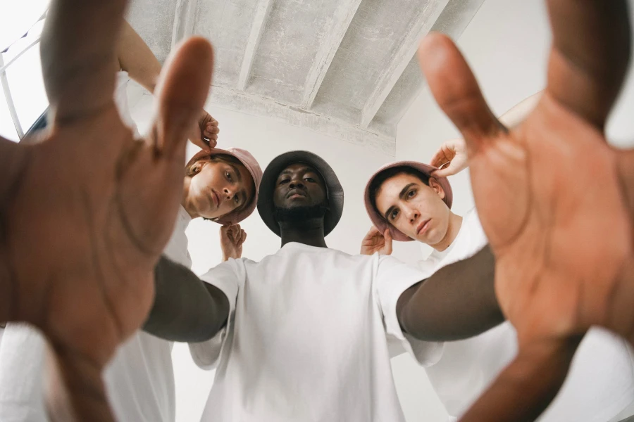 Three men wearing bucket hats and white shirts