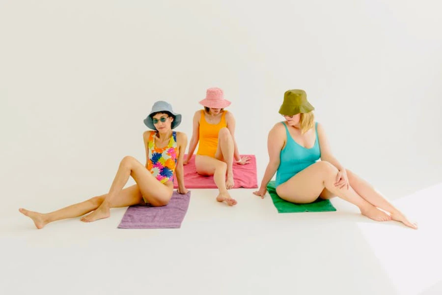 Three women wearing bucket hats and bathing suits