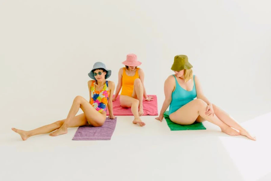 Trois femmes portant des chapeaux de seau et des maillots de bain