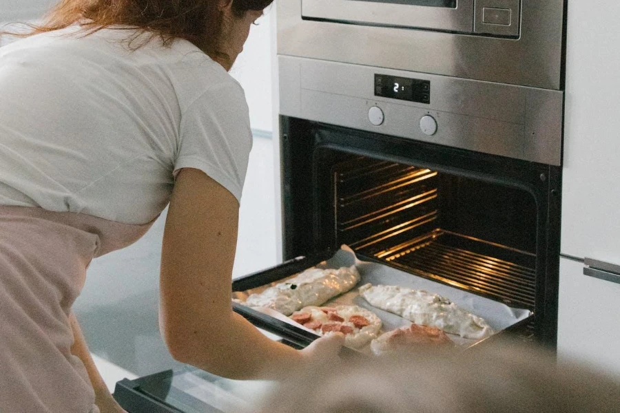 Woman putting a tray of dough into a smart oven