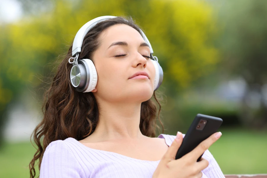 mujer con auriculares blancos escuchando música